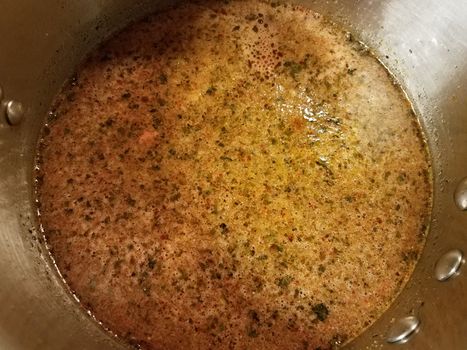 seasoned hot broth liquid in metal pan or pot