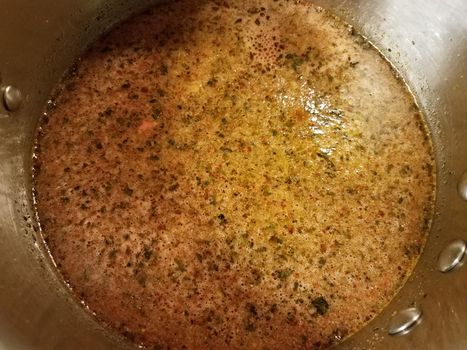 seasoned hot broth liquid in metal pan or pot