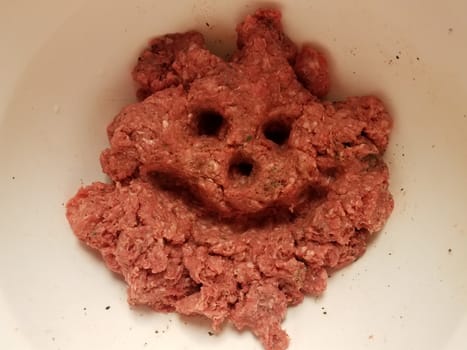 face with smile and eyes in raw pork in container or bowl