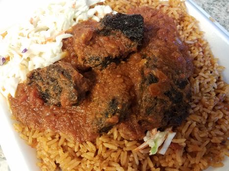 spicy goat and rice and cabbage African food in container