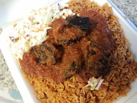 spicy goat and rice and cabbage African food in container