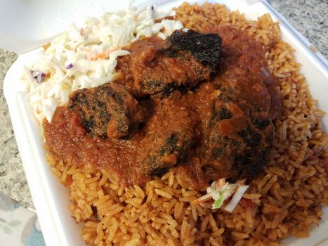 spicy goat and rice and cabbage African food in container