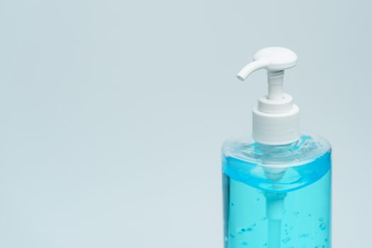 Clear blue hand sanitizer in a clear pump bottle on a white background.