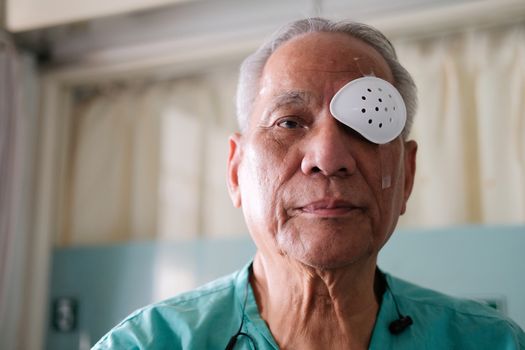 patient covering eye with protective shield & medical plaster after eyes cataract surgery in hospital