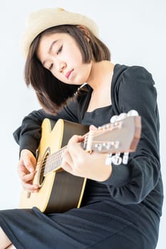 Close up Woman wear hat and playing guitar