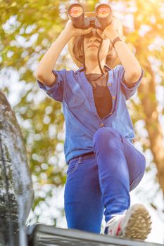 Close up Young asian woman short hair wear hat and hold binocular in grass field countryside Thailand