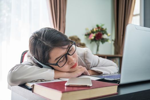 Teenage girl short hair sleep on desk after working on laptop while sit near window at home office