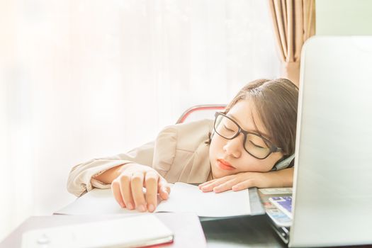 Teenage girl short hair sleep on desk after working on laptop while sit near window at home office