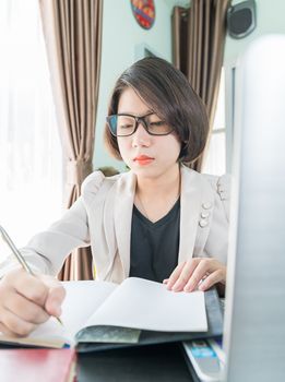 Teenage girl short hair in smart casual wear working on laptop while sit near window in home office