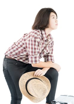 Young pretty woman in a cowboy hat and plaid shirt posing in studio with isolated on white background