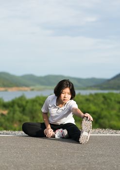 Woman runner doing exercises and warm up preparing for jogging outdoor