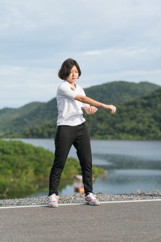 Fitness and lifestyle concept - Young asian woman short hair doing exercising outdoor