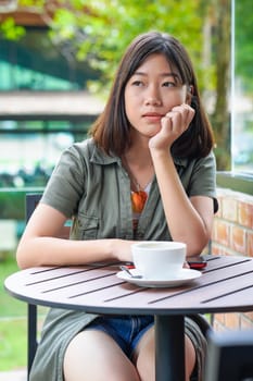 Pretty woman sitting in a cafe terrace with coffee cup