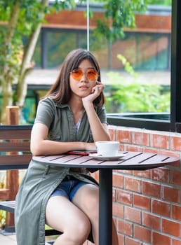 Pretty woman sitting in a cafe terrace with coffee cup