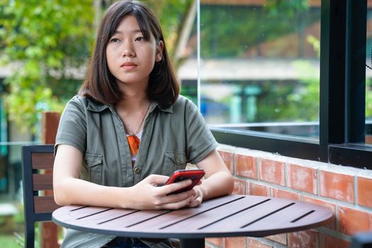 Pretty woman sitting in a cafe terrace use smartphone