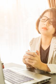 Woman teenage short hair in smart casual wear working on laptop while sit near window in home office