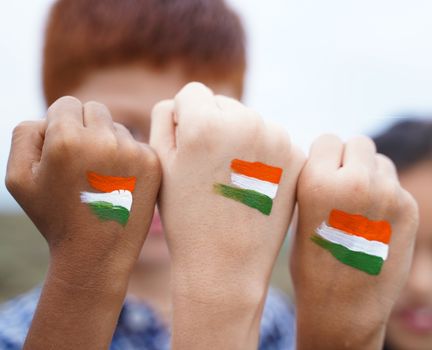 Kids fist hands painted with Indian falg during independence day or republic day celebration - concept showing of solidarity, raised fist of a protesters or patriotism.