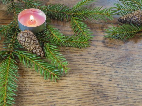 horizontal christmas decoration frame spruce tree fir branch with cone and tea light candle on old wooden desk background
