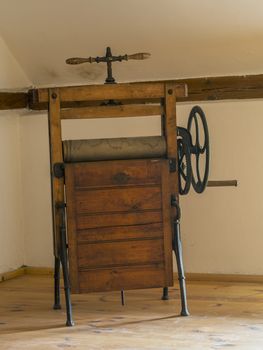 old antique wooden mangle rotary iron in attic room