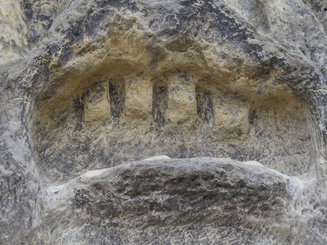 detail of mouth with teeth od devils head sculpted in 1846 by Vaclav Levy to the sand stone rock in Zelizy, czech republic