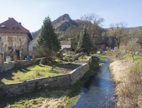 View on village with rver and rock cliff Svaty Jan pod Skalou, Beroun, Central Bohemian Region, Czech Republic, Famous pilgrimage place, spring sunny day, blue sky.