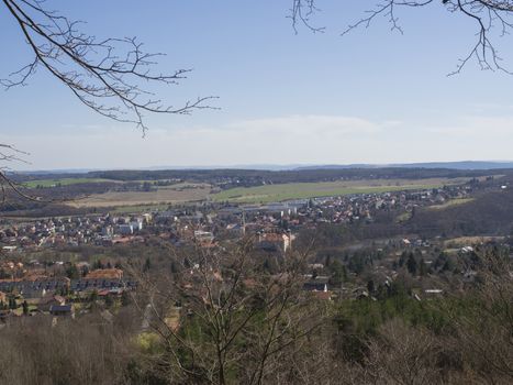 view on small city mnisek pod brdy in czech republic with trres, castle and buildings, early spring, blue sky background