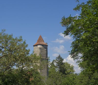 round stone tower of medieval castle Zvikov (Klingenberg) spring green trees and blue sky white clouds, South Bohemian Region, Czech Republic