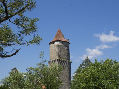 round stone tower of medieval castle Zvikov Klingenberg spring green trees and blue sky white clouds, South Bohemian Region, Czech Republic