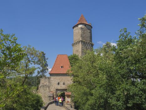 czech republic, Zvikov, May 26, 2018: group od people in main entry gate to medieval castle Zvikov (Klingenberg) with round tower and stone bridge, green trees and blue sky