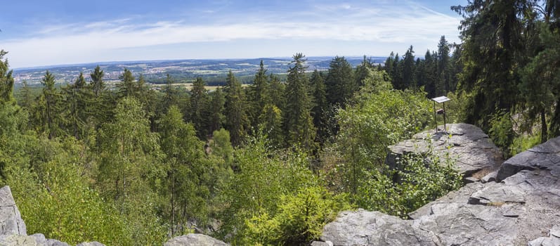 Panoramic view from look out in Brdy mountain hills, with green trees, rocks town and blue sky, Czech Republic.