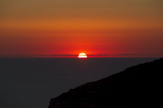 A beautiful sunset over calm Mediterranean waters at Dingli Cliffs in Malta
