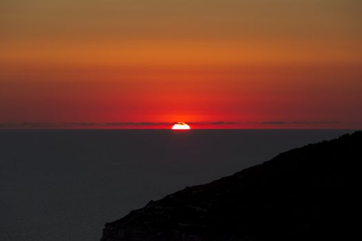 A beautiful sunset over calm Mediterranean waters at Dingli Cliffs in Malta