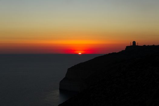 A beautiful sunset over calm Mediterranean waters at Dingli Cliffs in Malta