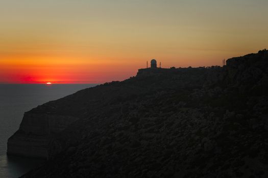 A beautiful sunset over calm Mediterranean waters at Dingli Cliffs in Malta