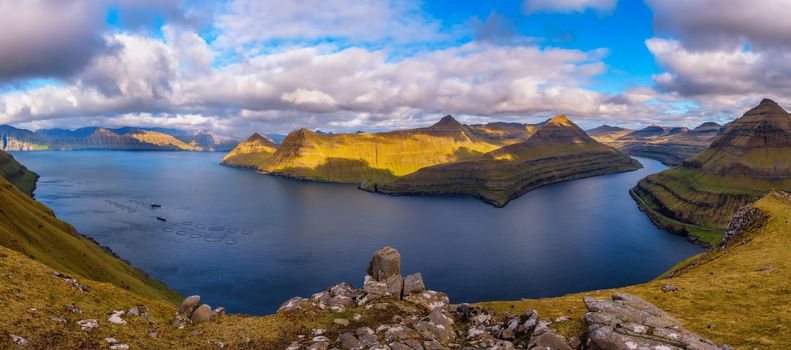 Panorama of spectacular mountains and fjords near the village of Funningur photographed from the Hvithamar mountain in Faroe Islands, Denmark.