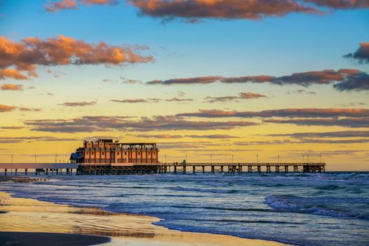 Sunrise above Daytona Beach Main Street Pier. Daytona Beach is known for its beach, where the hard-packed sand allows vehicles to drive on the beach.