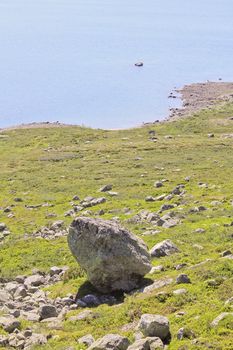 Huge boulder, big rock by the beautiful Vavatn lake in the mountains in Hemsedal, Buskerud, Norway.