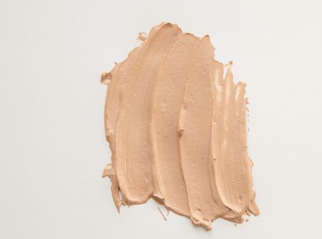 Foundation cream for makeup, make-up concept, smeared cosmetic cream on a white background.