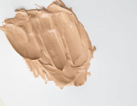 Foundation cream for makeup, make-up concept, smeared cosmetic cream on a white background.