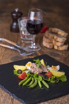 salad nicoise on a wooden background