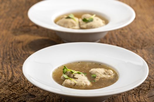 bavarian meat dumpling in broth on wood