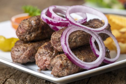 cevapcici on a plate on wood