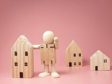 wooden doll stands next to the house. encouraging use of measures to Stay at home. stay at home.