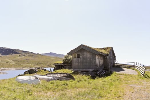 Small idyllic hut with fishing boats near the vavatn lake in Hemsedal, Buskerud, Norway.