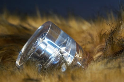 perfume bottle in yellow fur on a black background close-up