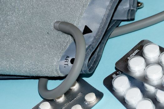 tonometer and pills close-up on blue background