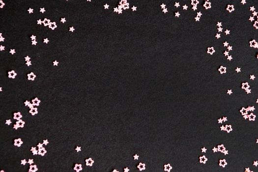 pink stars on black background, copy space.