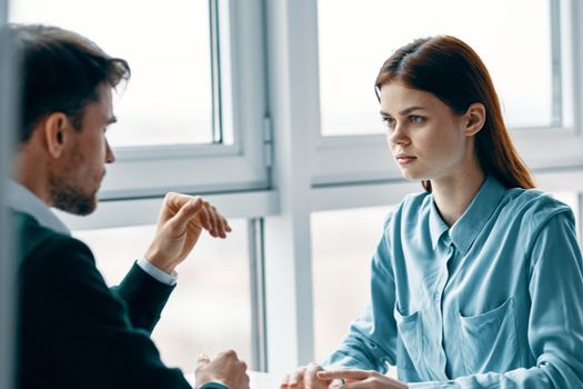 Beautiful young people at a table indoors near a cropped view window