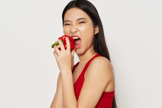 A woman of Asian appearance slender figure red pepper healthy eating vegetarian lifestyle