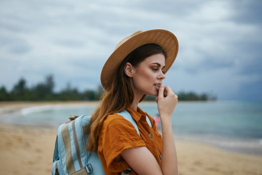 Romantic woman on the island with a backpack on her back near the ocean